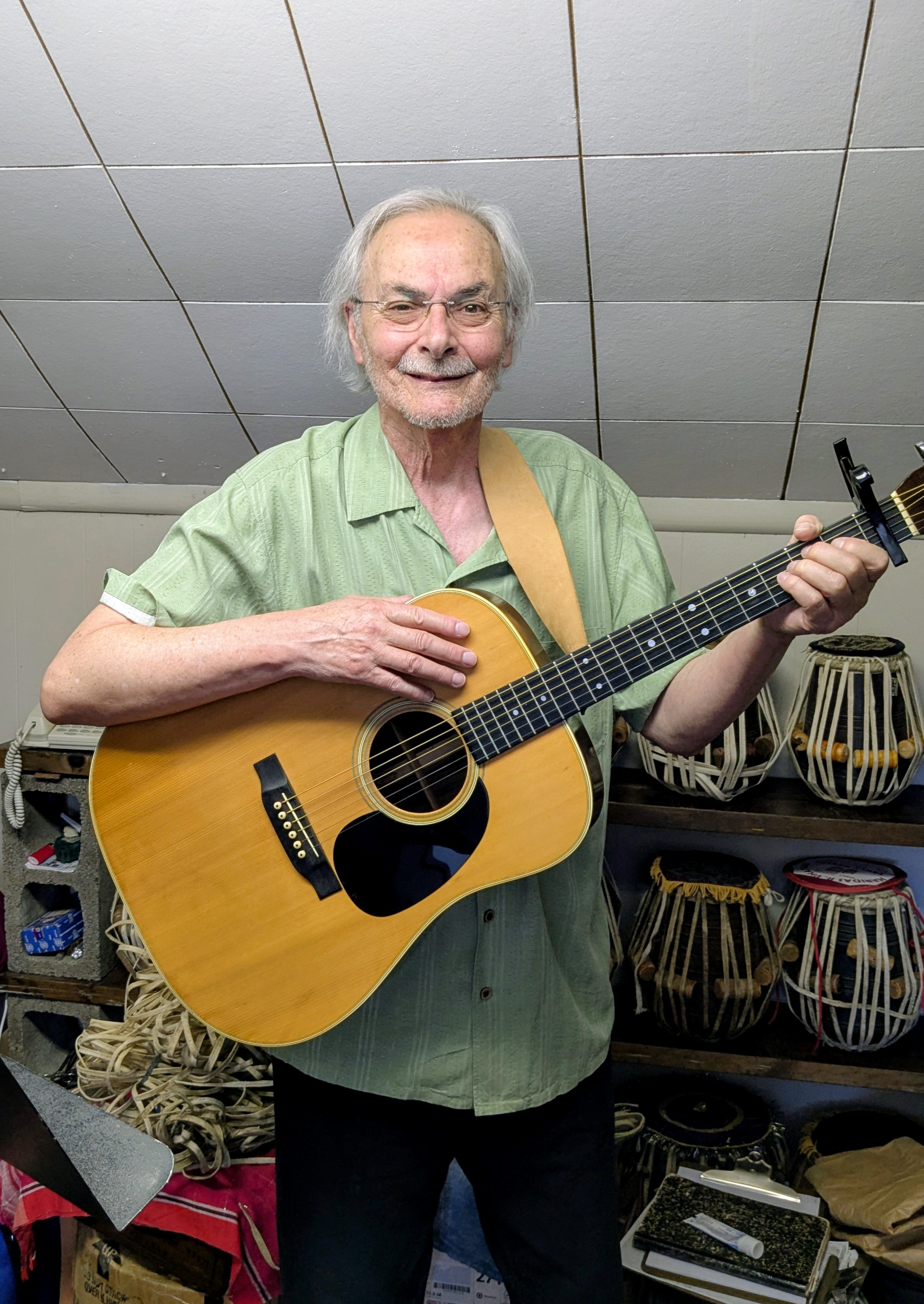 A picture of Doug Scheuerell holding his guitar.
